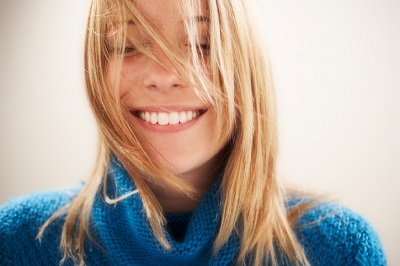 Beautiful smiling blonde woman with hair in face